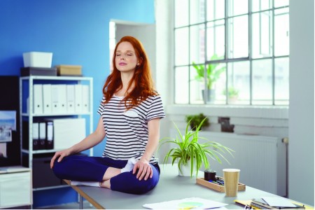 frau praktiziert yoga im büro