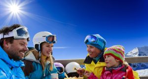 La montagne, un terrain de jeu 4 saisons La Montagne 4 saisons CSE : famille en randonnée face à un lac d’altitude et des sommets enneigés