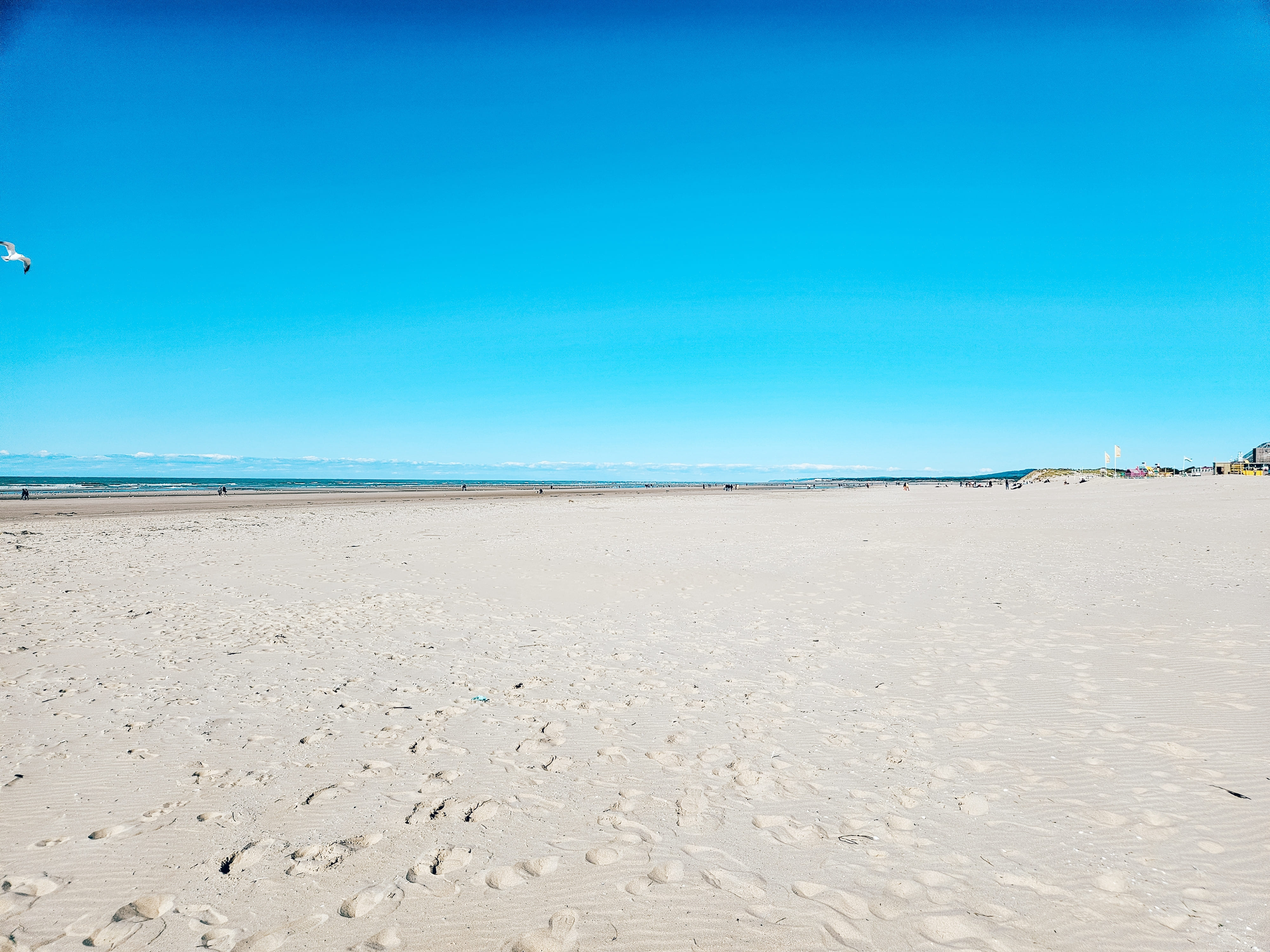 Station balnéaire adossée à une colline, front de mer et plage en basse saison
