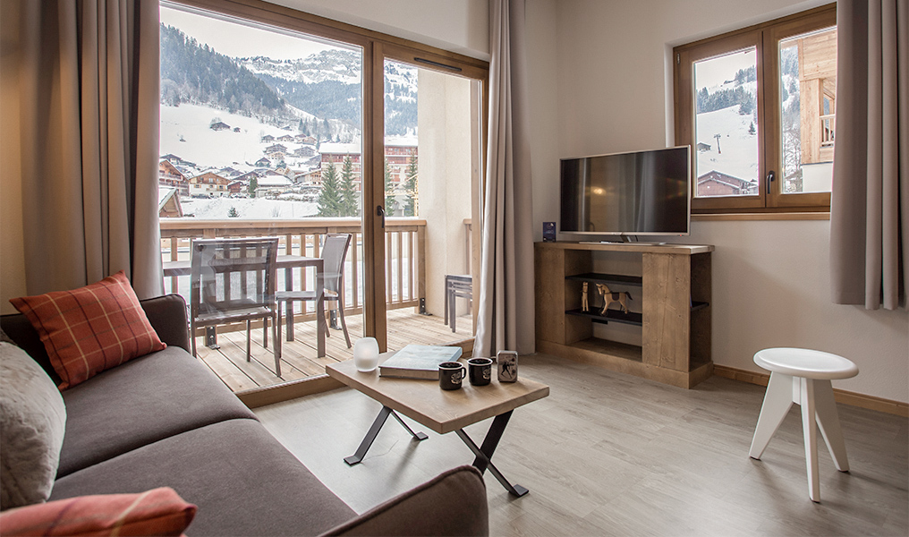 MMV CSE : le salon d’un appartement MMV avec sa baie vitrée ouverte sur la montagne